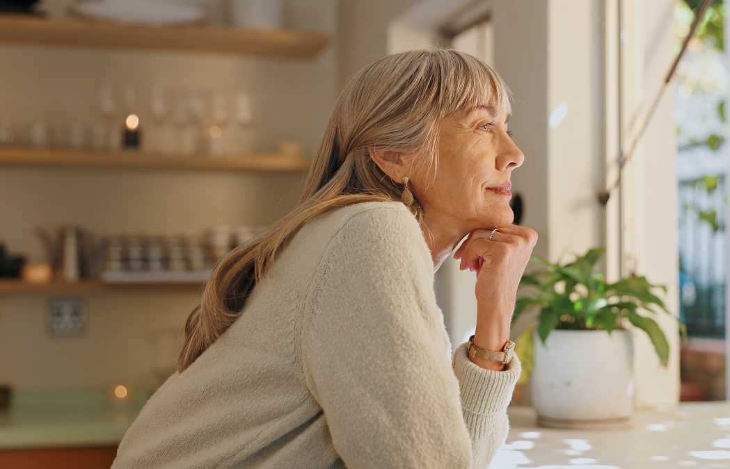 Window, smile and elderly woman with thinking at home for retirement, satisfaction and peace on weekend. Relax, senior person and calm with idea for reflection, mindfulness and good memory in house