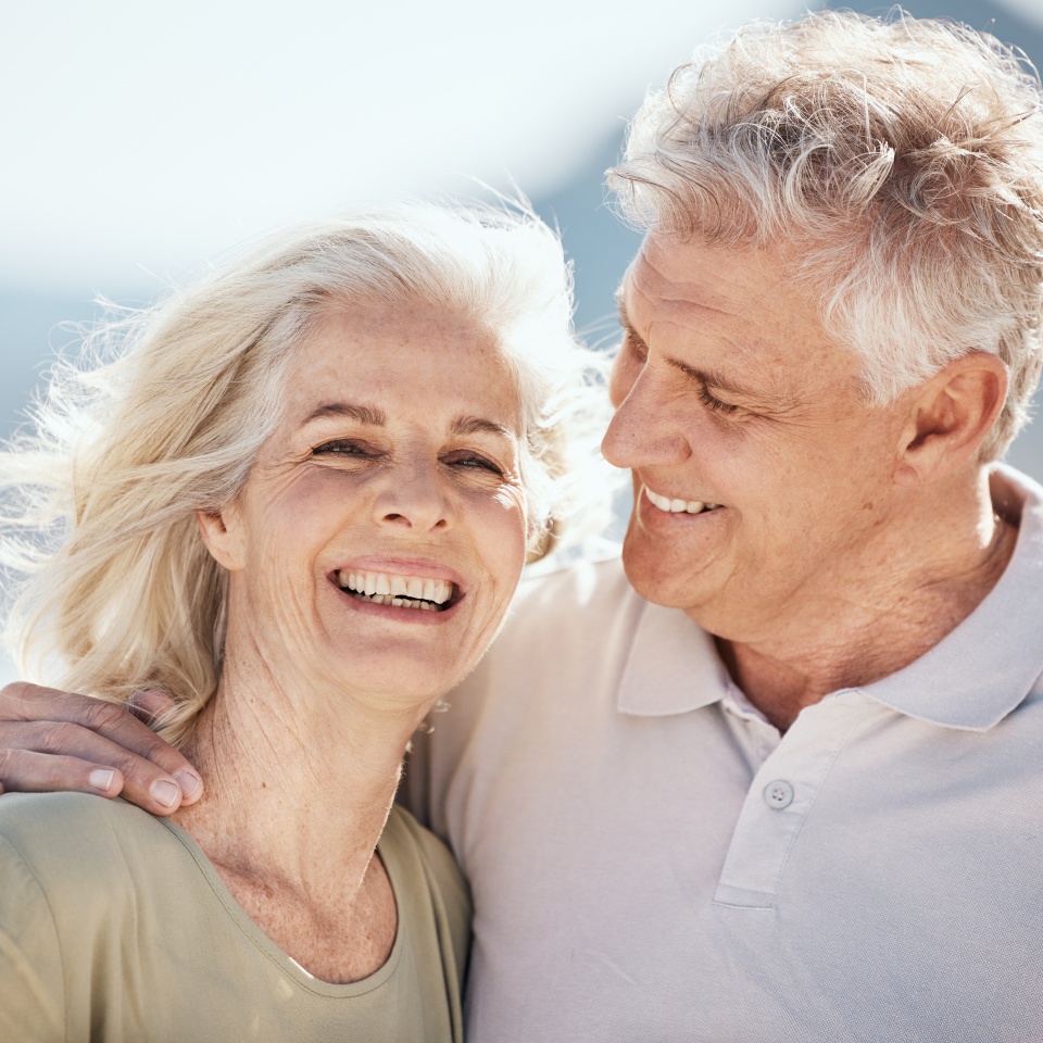 Senior couple, laughing and outdoor at beach with happiness, freedom and care on vacation. Face of a man and woman on retirement holiday, adventure and romantic trip in nature to relax and travel
