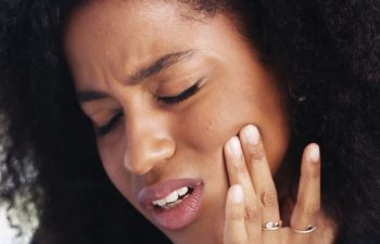 Toothache, sad and face of African woman at home for dental decay, poor oral hygiene and gum health pain. Gingivitis, bad breath and cavity bacteria with person for inflammation, tmj and crisis